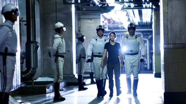 Jennifer Lawrence wird in „Die Tribute von Panem“ von Soldaten in Weiß eskortiert.