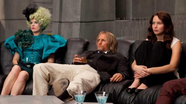 Jennifer Lawrence, Woody Harrelson und Elizabeth Banks sitzen auf einer Couch in „Die Tribute von Panem“.
