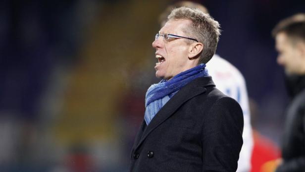 Ein Mann mit Brille und Schal schreit anscheinend, sein Atem ist sichtbar.