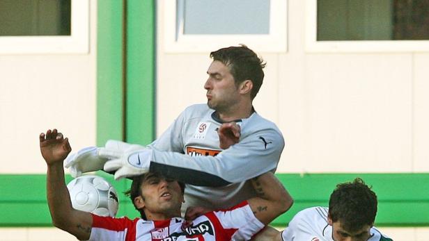 Ein Torwart fängt einen Fußball während eines Fußballspiels.