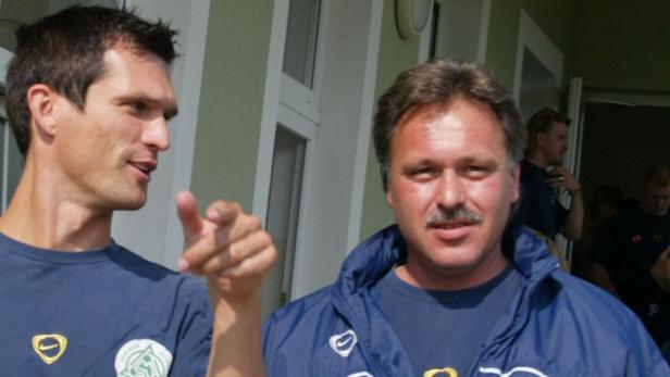 Zwei Männer, vermutlich Fußballtrainer und Spieler, stehen zusammen.