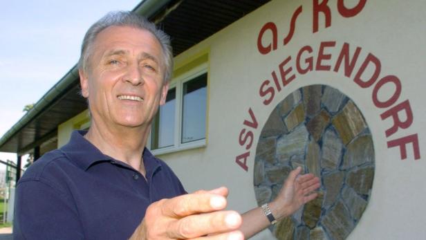 Ein Mann steht vor dem Vereinsheim des ASV Siegendorf und lächelt.