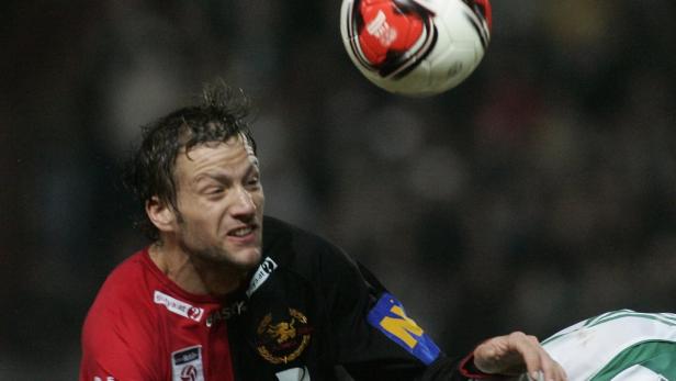 Ein Fußballspieler köpft einen Ball während eines Spiels.