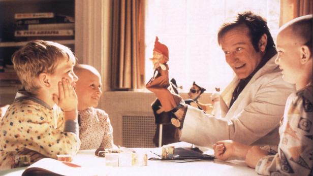 Robin Williams spielt mit einer Handpuppe für eine Gruppe Kinder.