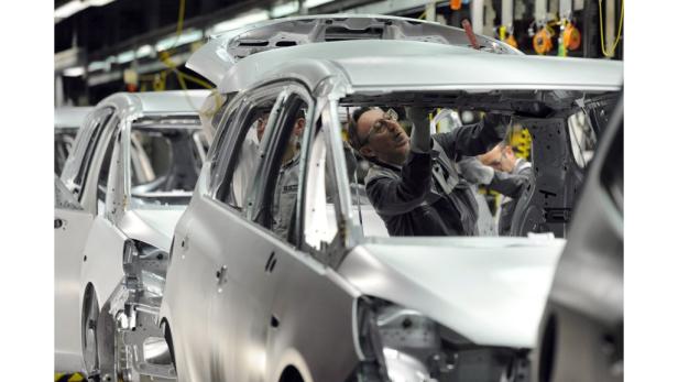 Ein Arbeiter montiert Teile in der Karosserie eines Autos in einer Fabrik.
