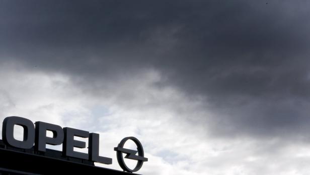 Das Opel-Logo vor einem bewölkten Himmel.