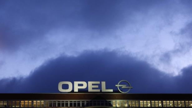Das Opel-Logo auf einem Gebäude unter einem bewölkten Himmel.