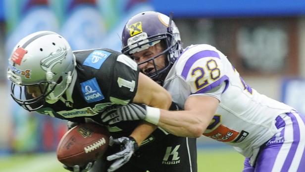 Zwei American-Football-Spieler kämpfen um den Ball.
