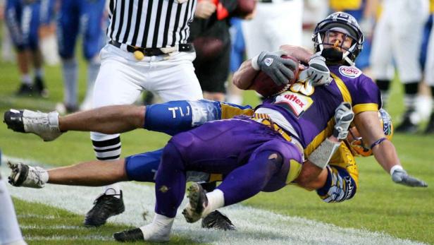 Ein American-Football-Spieler wird während eines Spiels zu Boden gebracht.