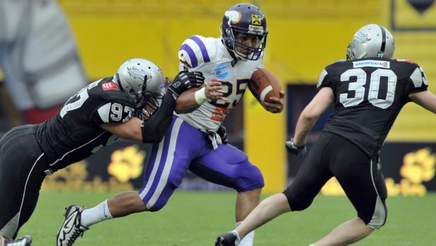 Ein American-Football-Spieler wird von zwei Verteidigern angegriffen.