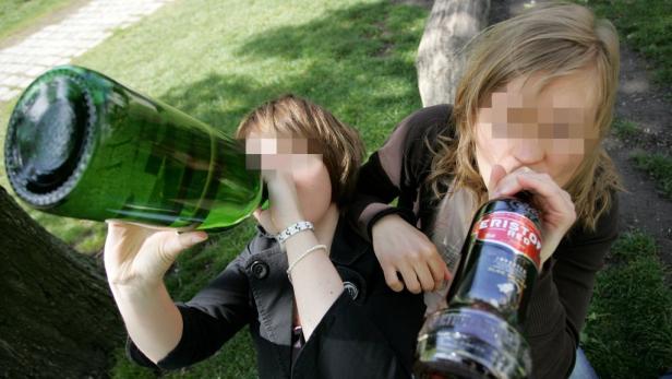 Zwei junge Frauen trinken Alkohol aus Flaschen im Freien.
