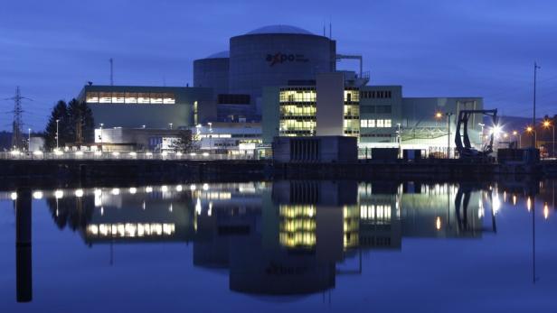 Das Kernkraftwerk Beznau in der blauen Stunde spiegelt sich im Wasser.