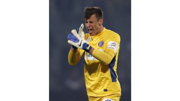 Ein Torwart in gelbem Trikot gestikuliert auf dem Spielfeld.