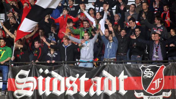 Fußballfans jubeln hinter einem Banner mit der Aufschrift „Südstadt“.