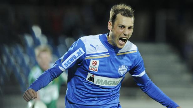 Ein Fußballspieler in blauem Trikot jubelt mit geballten Fäusten.