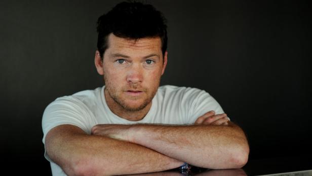 Ein Mann mit roten Haaren und Sommersprossen blickt in die Kamera.