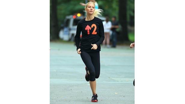 Gwyneth Paltrow joggt in Sportkleidung durch einen Park.