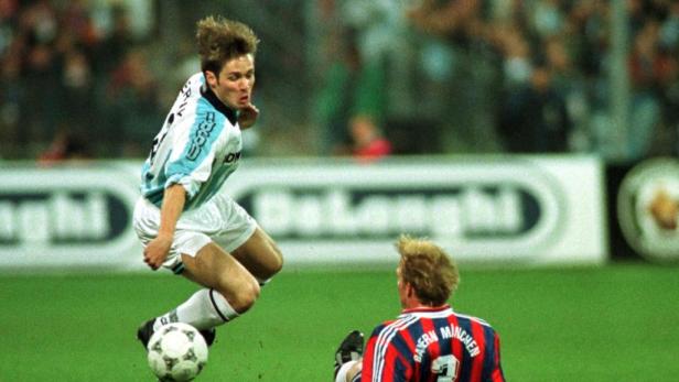 Ein Fußballspieler dribbelt den Ball, während ein anderer Spieler ihm gegenüber steht.