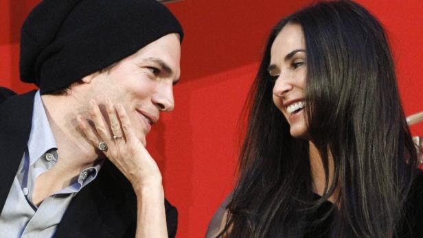 Ashton Kutcher und Demi Moore lächeln sich an.