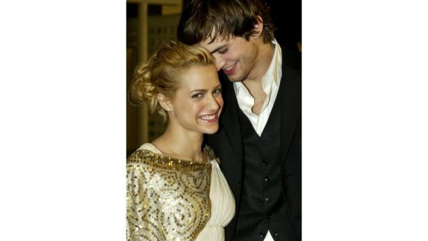 Brittany Murphy und Ashton Kutcher posieren lächelnd für ein Foto.