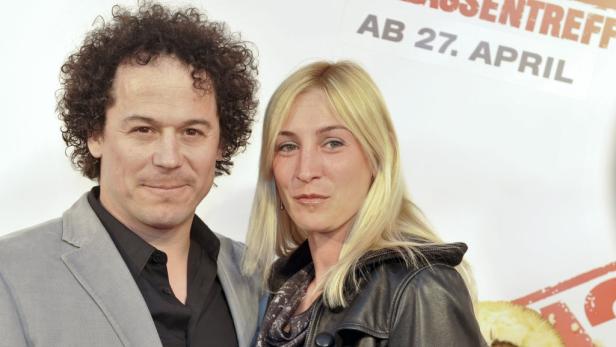Schauspieler Oliver Mommsen mit einer blonden Frau auf einem Event.