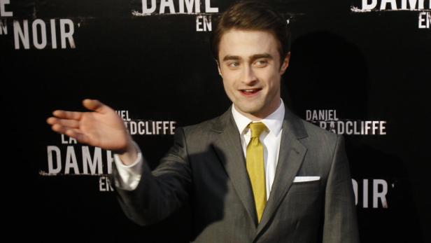 Daniel Radcliffe posiert vor einem Plakat für „Die Frau in Schwarz“.