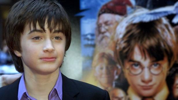 Daniel Radcliffe posiert vor einem Poster von „Harry Potter“.