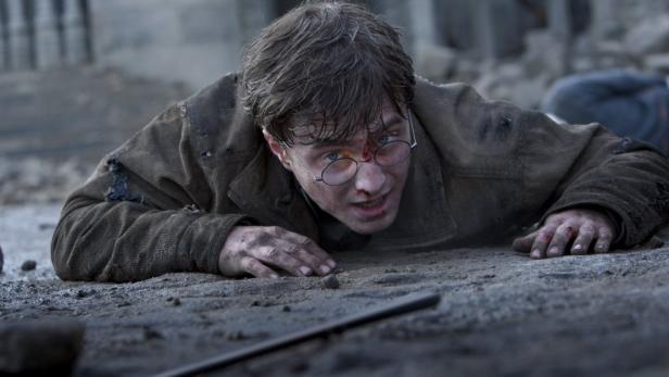 Ein erschöpfter und verletzter Harry Potter liegt am Boden.