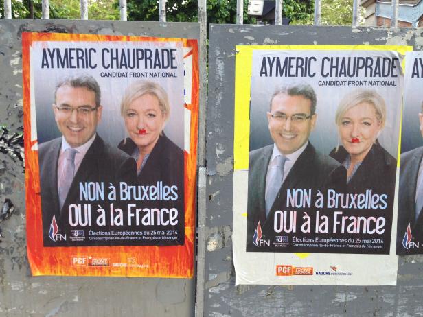 Zwei Wahlplakate von Aymeric Chauprade und Marine Le Pen, beide mit roter Farbe im Gesicht.