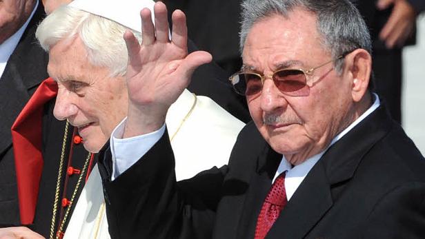 Raúl Castro und Papst Benedikt XVI. winken in die Menge.