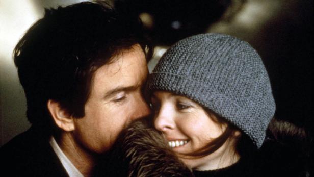 Ein Mann und eine Frau, die eine graue Mütze trägt, stehen eng beieinander.