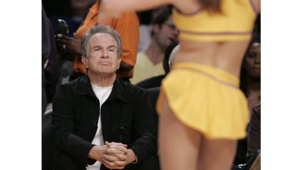 Ein Mann sitzt am Spielfeldrand und schaut einer Tänzerin zu.