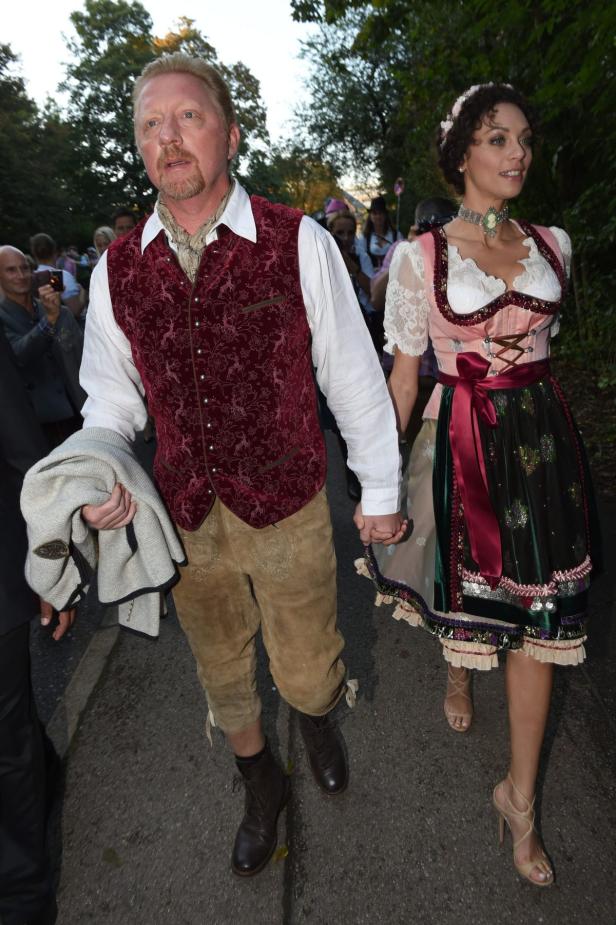 Boris Becker und eine Frau im Dirndl halten Händchen.