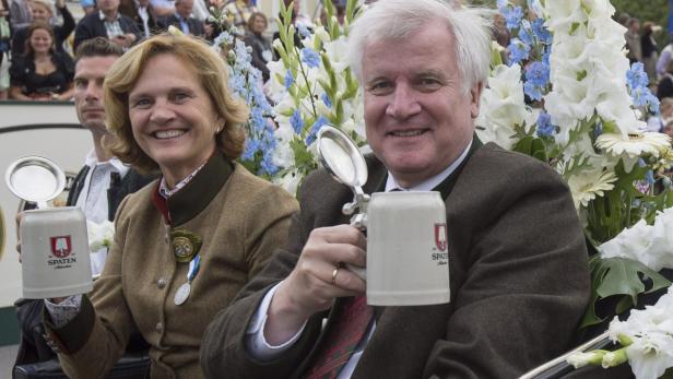 Horst Seehofer und seine Frau mit Bierkrügen der Marke Spaten auf einer Veranstaltung.