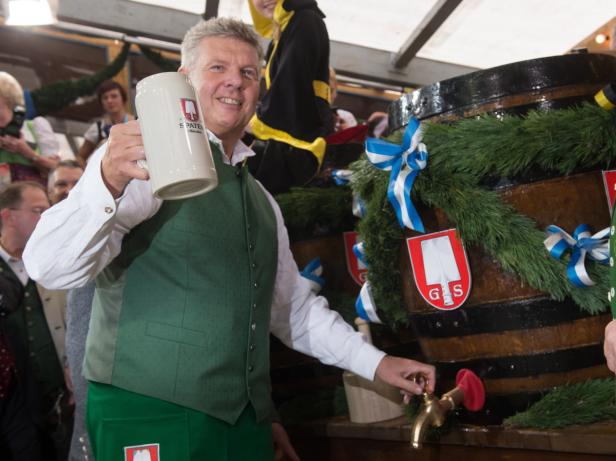 Ein Mann im Trachtenlook zapft Bier in einen Krug.