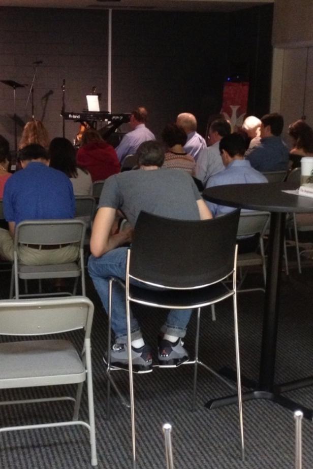 Menschen sitzen in einem Raum, möglicherweise bei einer Veranstaltung oder einem Gottesdienst.