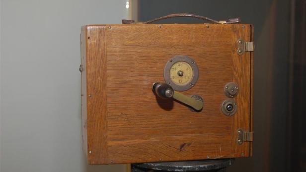 Eine antike Holzkamera mit einem Einstellrad und einem Griff.