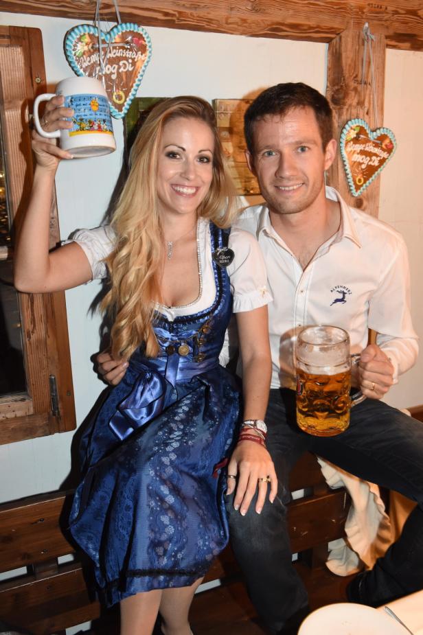 Ein Paar in Tracht sitzt mit Bierkrügen in einem bayerischen Lokal.
