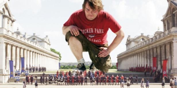 Jack Black als riesiger Gulliver steht vor einer Menschenmenge und Gebäuden.