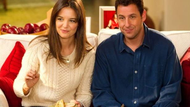 Katie Holmes und Adam Sandler sitzen auf einer Couch.
