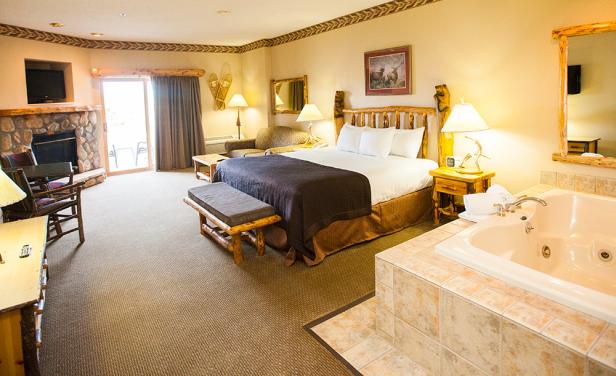 Ein Hotelzimmer mit Kamin, Whirlpool und einem großen Bett.