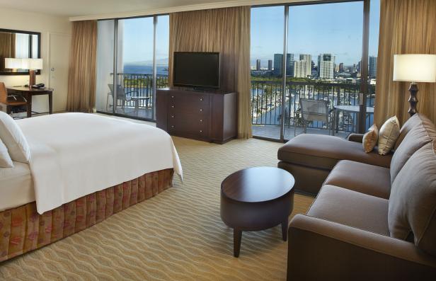 Ein Hotelzimmer mit Blick auf einen Yachthafen und die Skyline der Stadt.