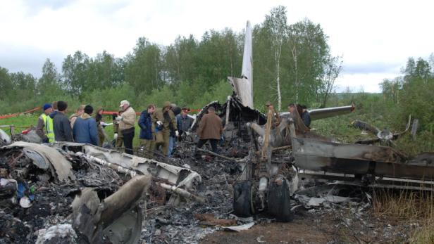 Menschen stehen um die Trümmer eines Flugzeugabsturzes.