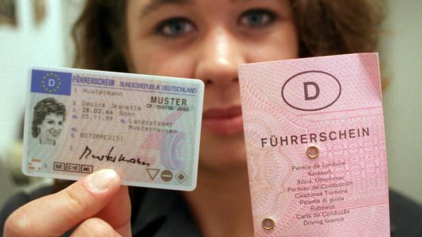 Eine Frau hält einen deutschen Führerschein in die Kamera.