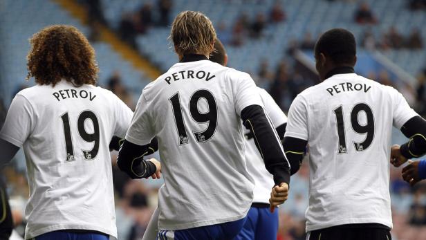 Drei Fußballspieler tragen T-Shirts mit der Aufschrift „Petrov 19“.