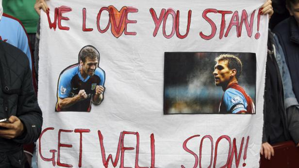 Ein Transparent mit der Aufschrift „We love you Stan! Get well soon!“ und Bildern eines Fußballspielers.