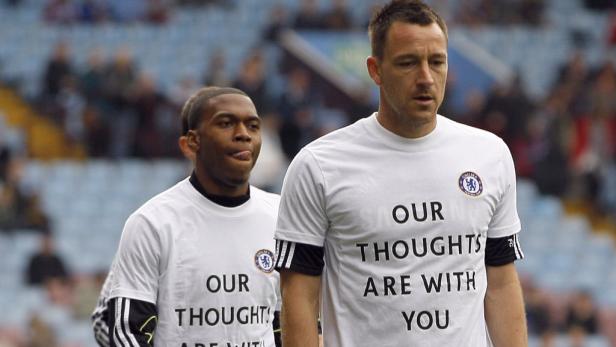 Zwei Chelsea-Spieler tragen T-Shirts mit der Aufschrift „Our thoughts are with you“.