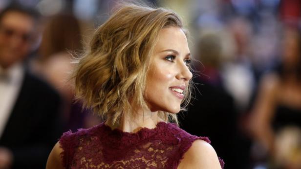 Scarlett Johansson lächelt auf einem roten Teppich.