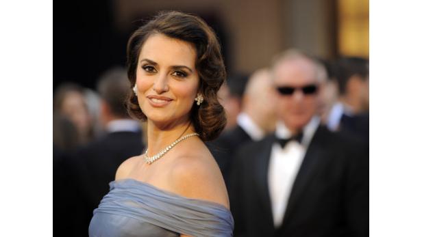 Penélope Cruz auf dem roten Teppich, gekleidet in einer eleganten Robe und mit funkelndem Schmuck.