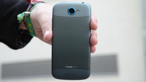 Eine Hand hält ein graues HTC-Smartphone mit Beats Audio Logo.